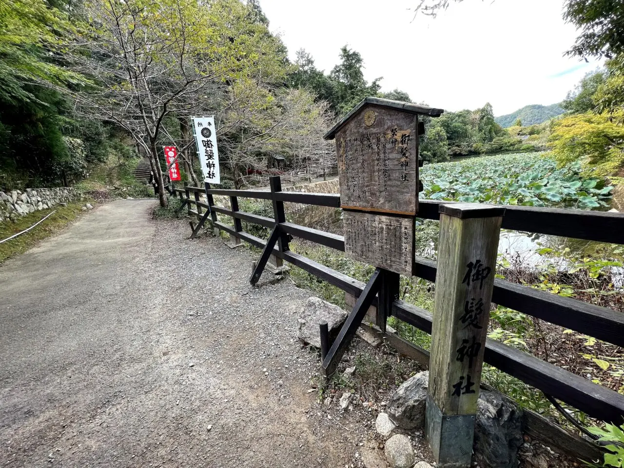 御髪神社の参道入口と小倉池沿いの案内板