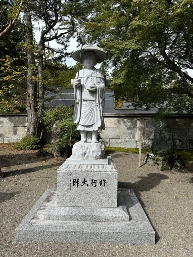 木々に囲まれた高野山内の修行大師像