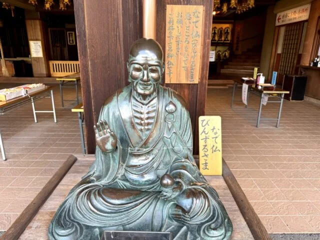 廊下近くに座る像と案内札