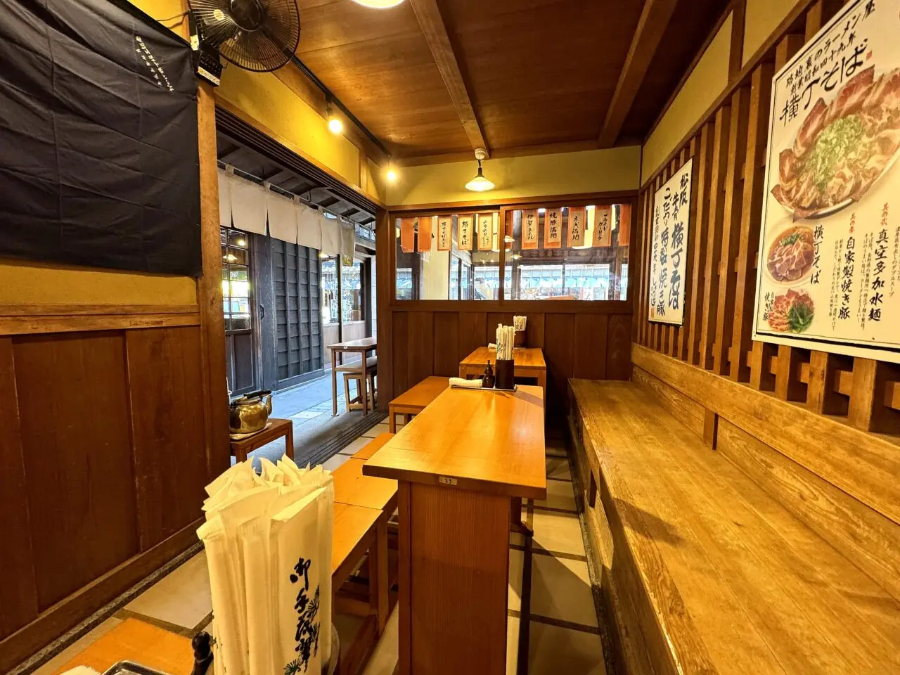 横丁そば小西湖の店内テーブル席と壁の案内