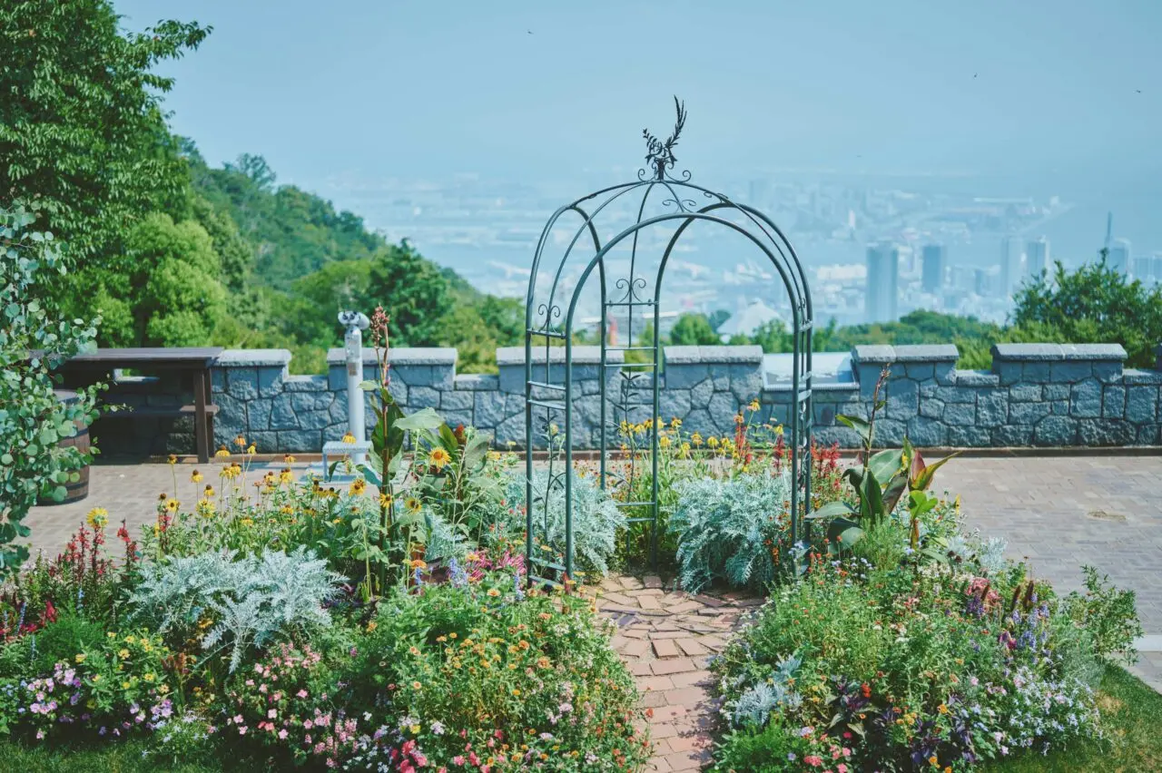 神戸布引ハーブ園の夏の園内公式写真。花壇と神戸の眺望を示す。