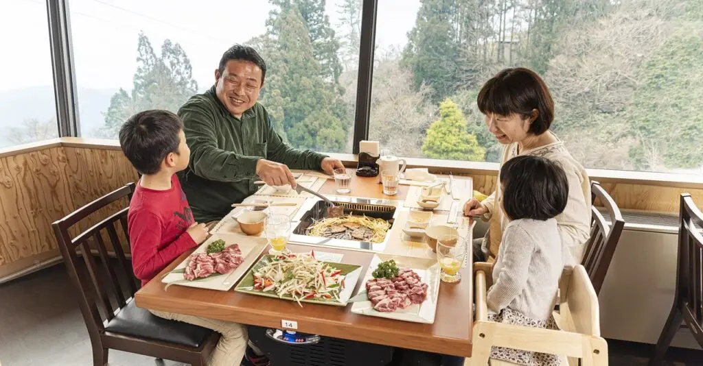 六甲山ジンギスカンパレスの公式掲載写真。店内で食事する家族の様子を示す。
