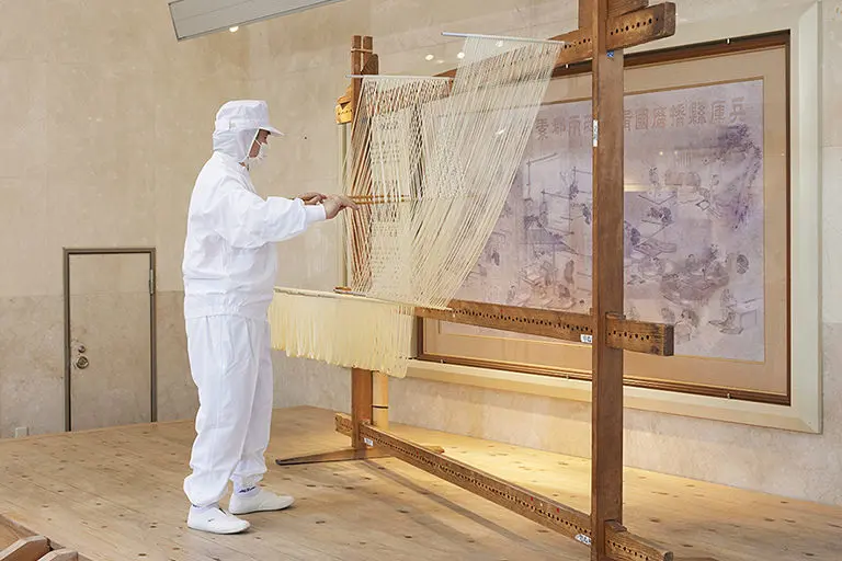 揖保乃糸資料館 そうめんの里の公式実演コーナー画像。手延べそうめんの作業実演を示す。