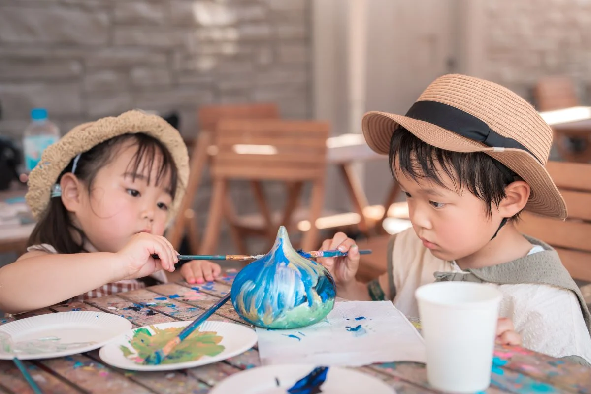 ニジゲンノモリ公式掲載のスライム色塗り体験。子どもがスライムの素焼きに色を塗っている。