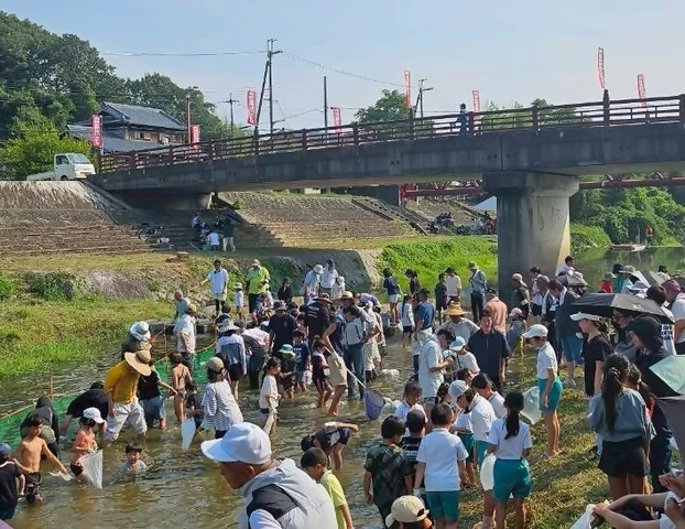 神戸市公式イベントサイト掲載の押部谷明石川まつり会場イメージ。明石川で魚のつかみどりを楽しむ来場者。