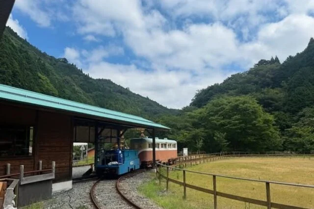 山あいの線路で青い機関車が客車を引く一円電車。主催者の告知ページに掲載された写真で、2026年10月4日の開催当日写真ではありません。