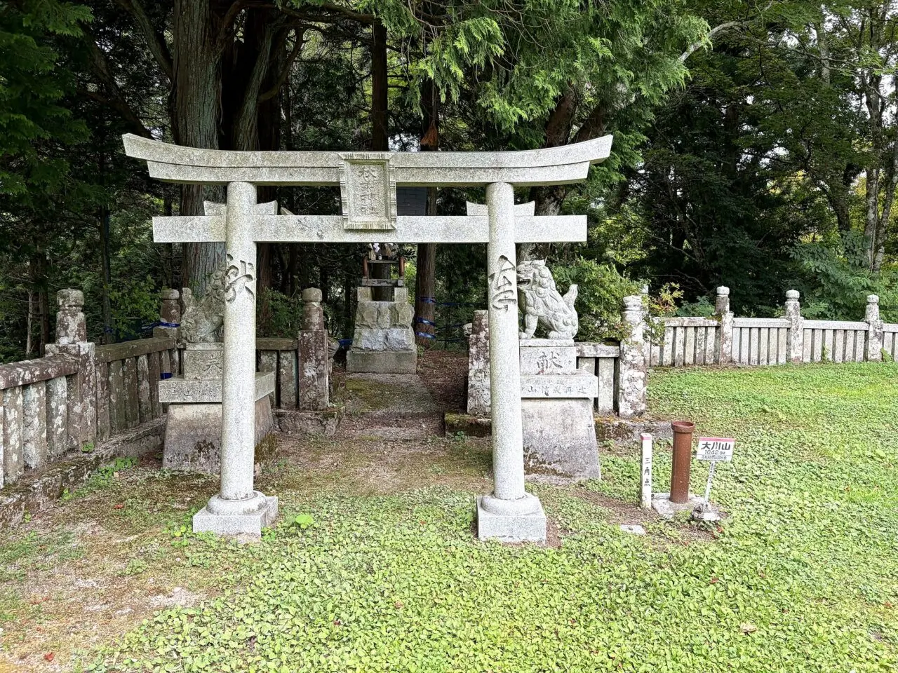 石鳥居と狛犬の横にある大川山山頂標識