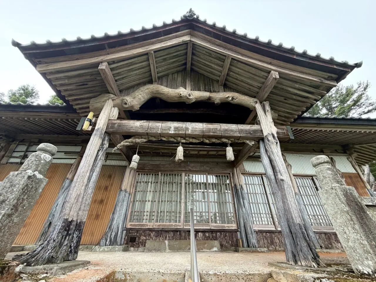 太い木組みとしめ縄がある大川神社社殿正面