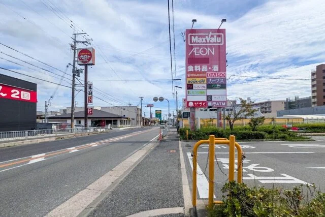国道2号沿いの道路と周辺看板。左奥にガストの看板が見える