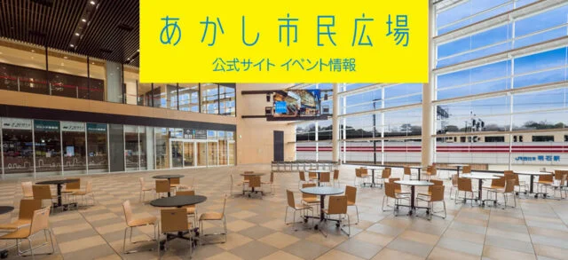 テーブルと椅子が並び、大きな窓の向こうに駅側の景色が見えるあかし市民広場の館内
