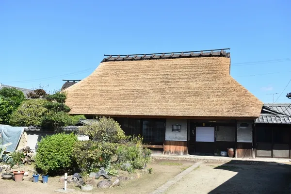 厚い茅葺屋根と木造の正面が見える奥田家住宅