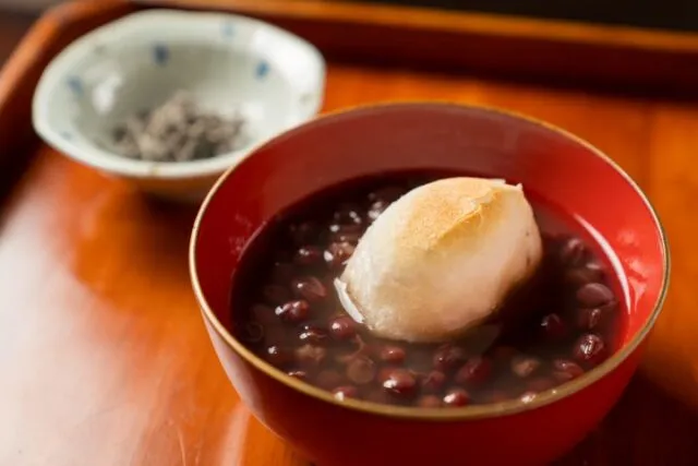 赤い器に入った丹波大納言小豆のぜんざいと、焼き餅