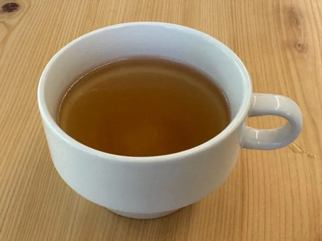 木のテーブルに置かれたスープの器