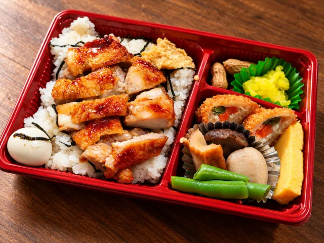 とりめし弁当（定番）の公式メニュー写真。照り焼きチキンを載せた出汁ご飯とコロッケ、卵焼き