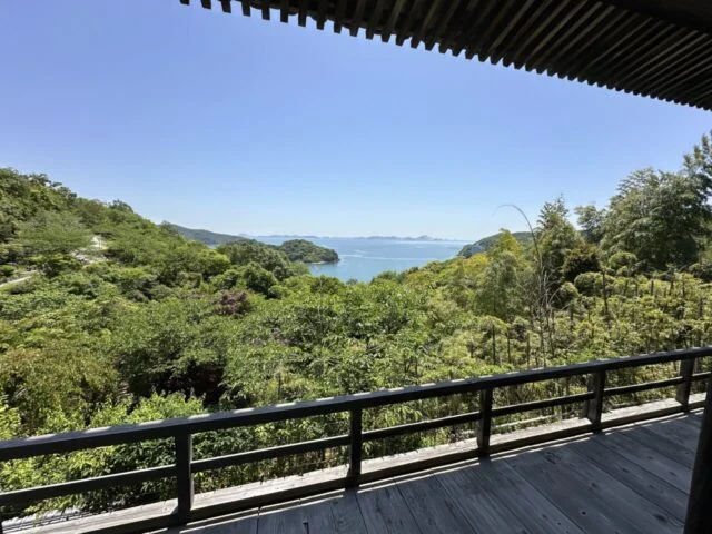 観音堂の木の欄干越しに広がる坂越湾と生島