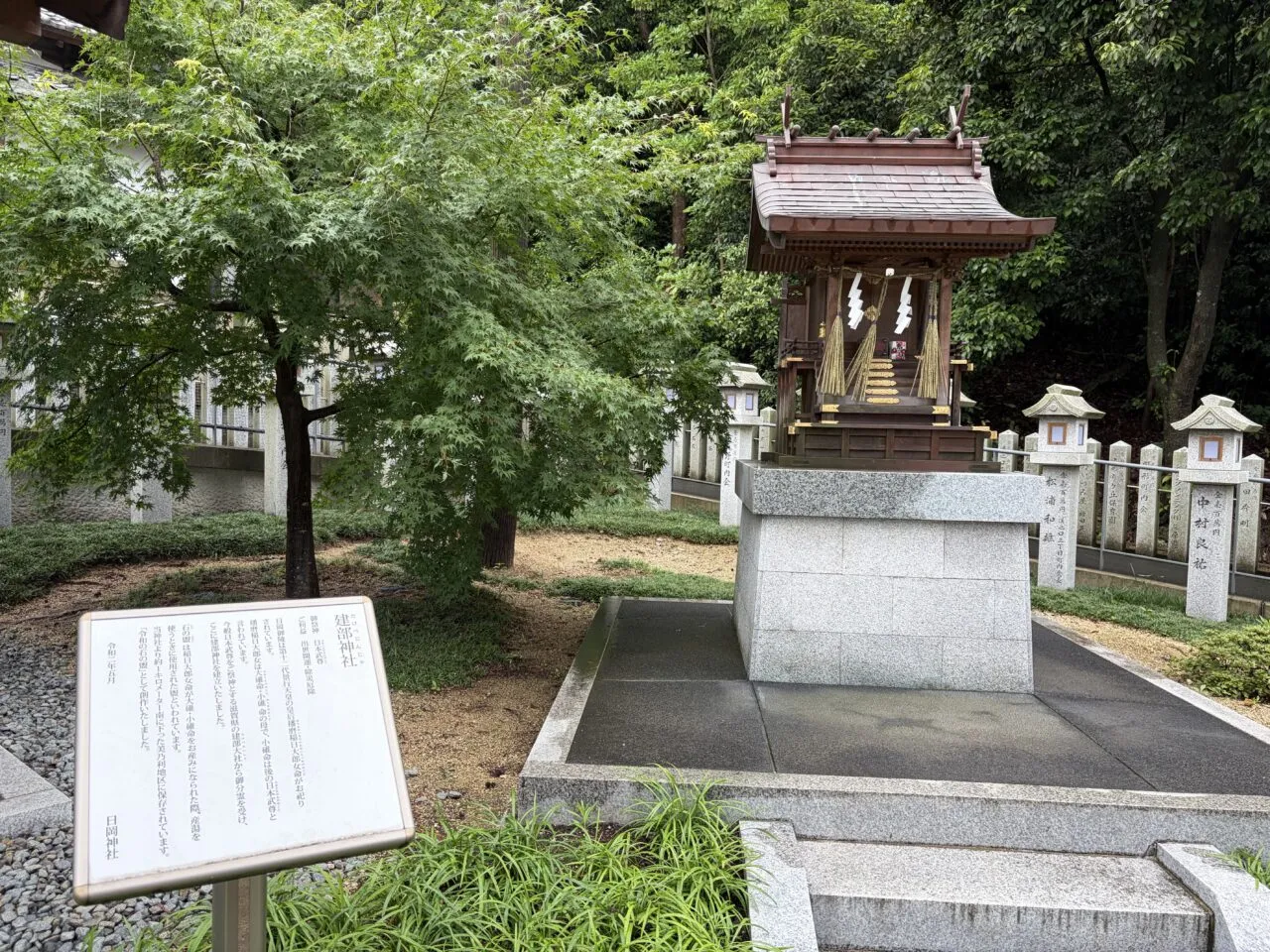 建部神社の社殿と由緒板。玉垣と石段が目印(2026年6月27日撮影)。