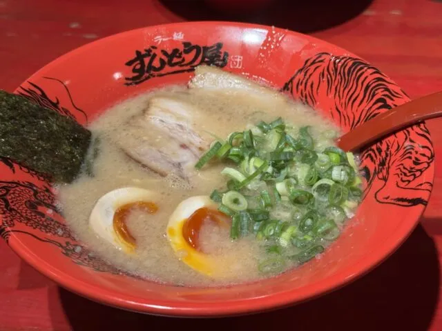 赤い器のラーメン。海苔、ねぎ、味玉などの盛付けが分かる2025年8月12日の写真