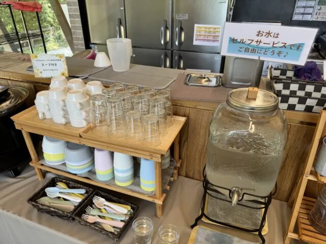 セルフサービスの水と子ども用カップ、カトラリー