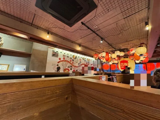 木の間仕切りと店内の座席。2025年8月12日撮影