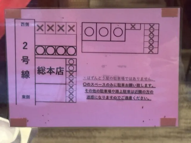 総本店の店舗前・横・裏を示すピンク色の駐車場案内図。2025年8月12日撮影