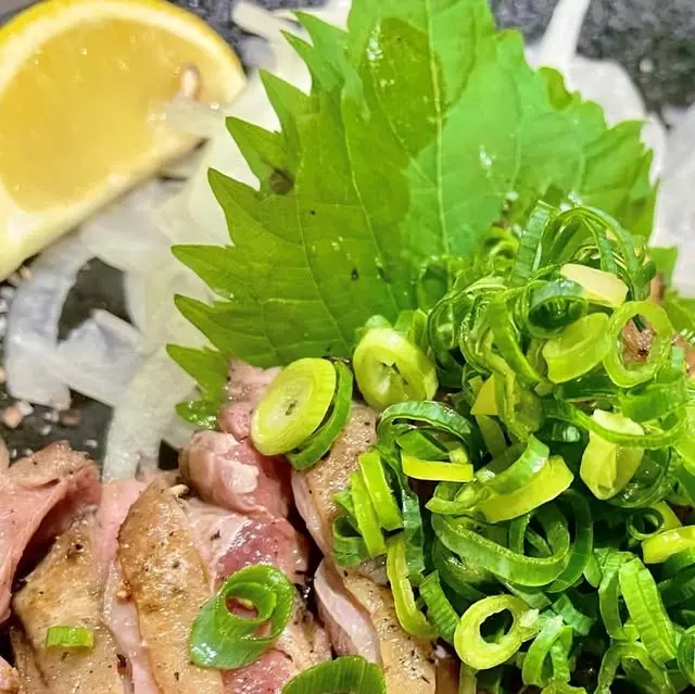 薄切りのひね鶏に青ねぎと大葉、玉ねぎ、レモンを添えた公式料理写真