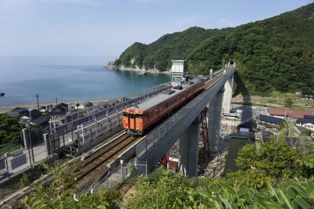 現在の橋を走る列車、旧鉄橋の展望路とガラス張りの昇降施設