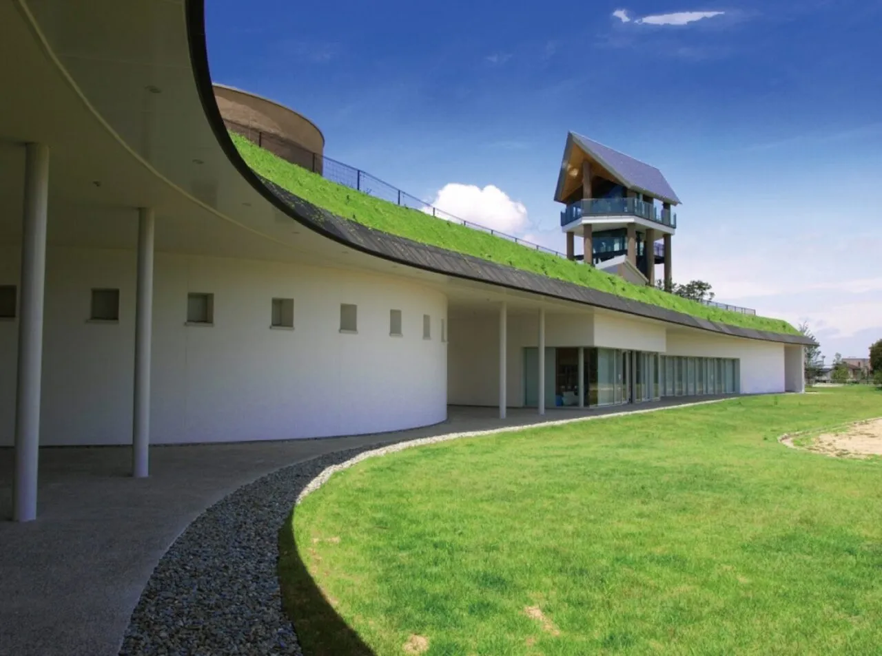 兵庫県立考古博物館の白い曲線状の建物、緑化した屋根と、その奥の展望塔