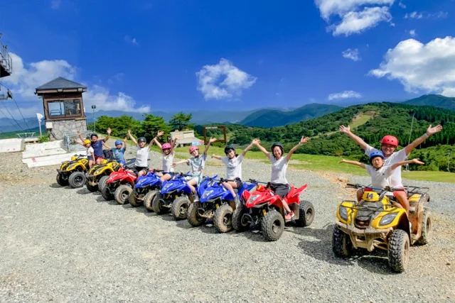 峰山高原の公式バギー体験写真。ヘルメットを着けた参加者が赤・黄・青の四輪バギーで山頂に並ぶ