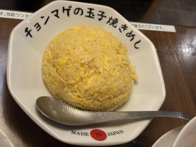 チョンマゲの玉子焼きめし。玉子をまとったご飯が丸く盛られ、手前にスプーンがある