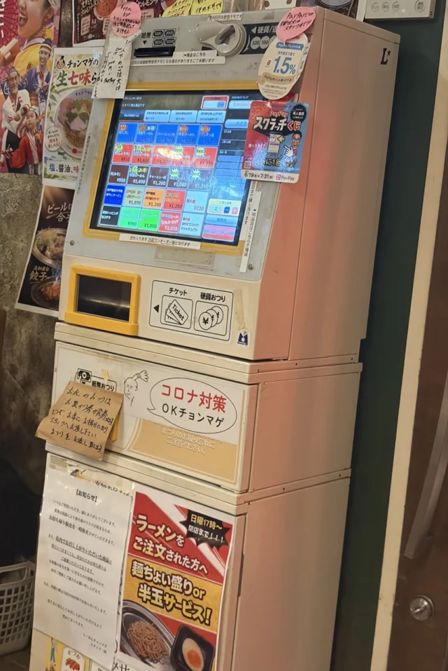 撮影時の券売機。ラーメンを選ぶ画面と食券・釣り銭の取出口