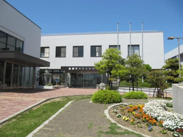 播磨町中央公民館の白い外壁とガラス張りの正面入口、前庭の施設紹介写真
