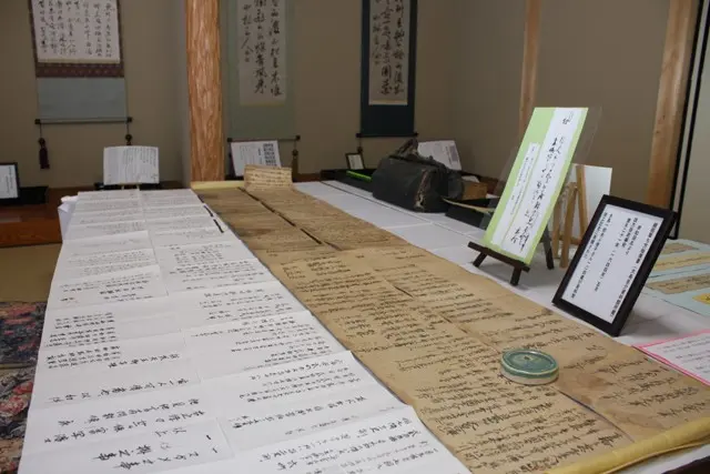 机に並んだ大鳥圭介関連文書と掛け軸などの館内展示