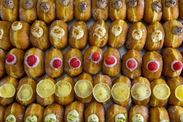 PIECE OF BAKE公式の商品写真。砂糖をまとった丸いドーナツに、クリームやフルーツをのせたボンボローニ