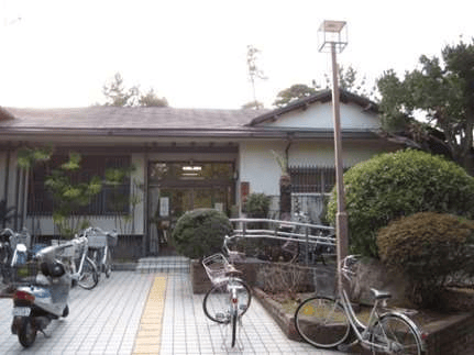 広田山荘の平屋の外観。正面入口へ続く通路と植栽