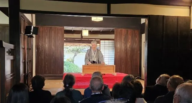 宝塚市のイベント案内に掲載された過去の落語会写真。木の柱のある座敷で演者と客席が向き合う様子