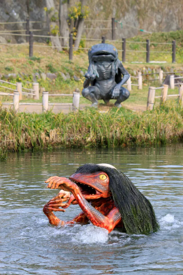 水面から顔を出す河次郎と、池の奥に座る河太郎