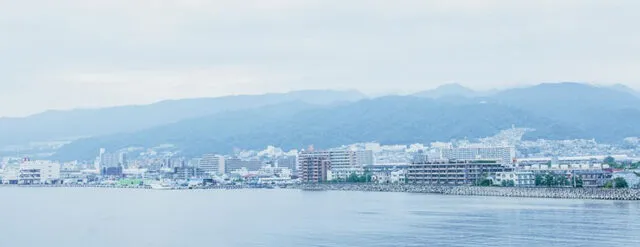 あしや喜楽苑の公式施設案内に掲載された、海辺の街並みと山並みの風景