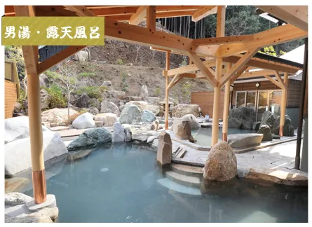 ふところ館の露天風呂。木の屋根と自然石、湯船の段差が見える