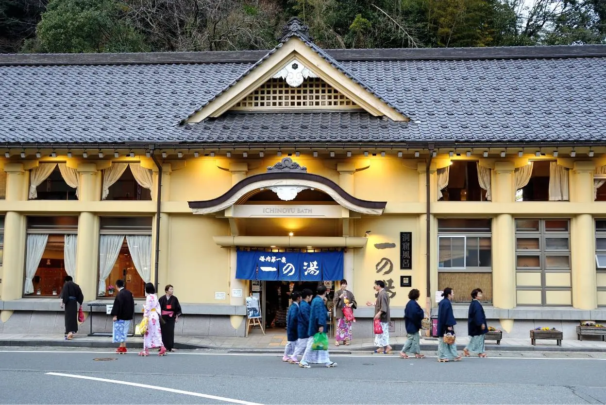 城崎温泉の公共浴場一の湯の入口と温泉街を歩く人々