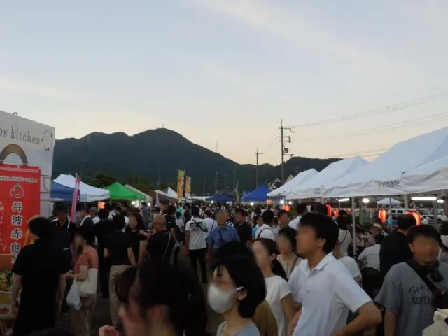 2024年の久下村夜市で、山を背景にテントが並ぶ会場