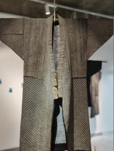 公式チラシに掲載された、広い袖と長い身頃に細かな模様があるドンザ