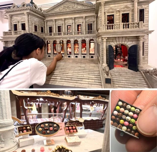 公式資料のミニチュア作品。小さな箱を指に載せた写真と、建物の窓・店内を作り込んだ作品の写真