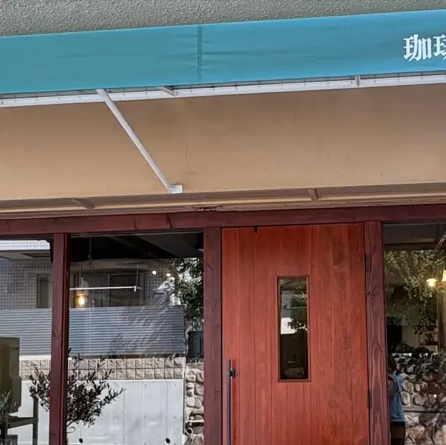 珈琲と。つくえの店頭。木製の扉と青緑色の庇が目印