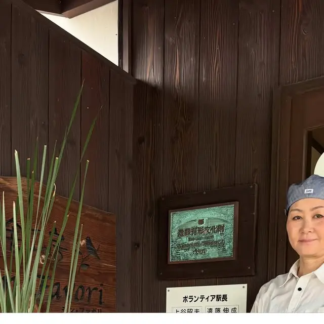 法華口駅舎の木壁と人物。閉業を知らせた2026年9月30日の公式投稿の写真