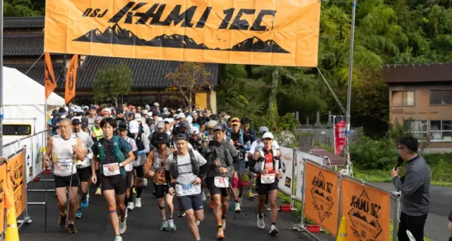 公式サイト掲載の過去のスタート風景。山間の会場にオレンジ色の大会幕が掲げられている