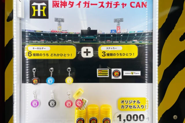 キーホルダー6種類とステッカー3種類の公式商品案内。価格は1回1,000円