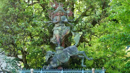 妙光院の馬頭観世音菩薩像。馬の背に立つ大きな像を木々が囲む