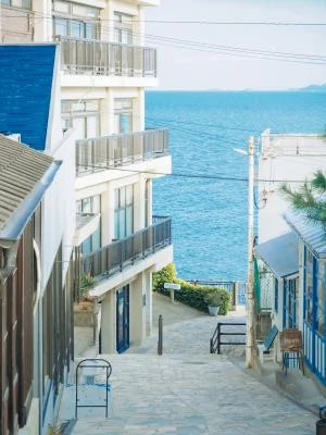 きらきら坂の石畳と道沿いの建物、その先に広がる瀬戸内海