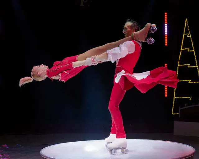 赤と白の衣装でローラースケート演技をするThe Crystal Wheels。公式の出演者紹介写真