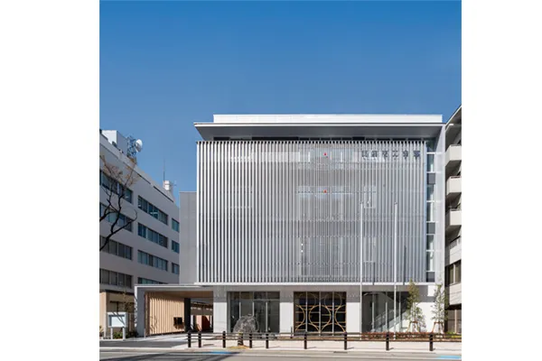 西宮商工会館の外観。白い縦ルーバーに覆われた正面と1階の入口。